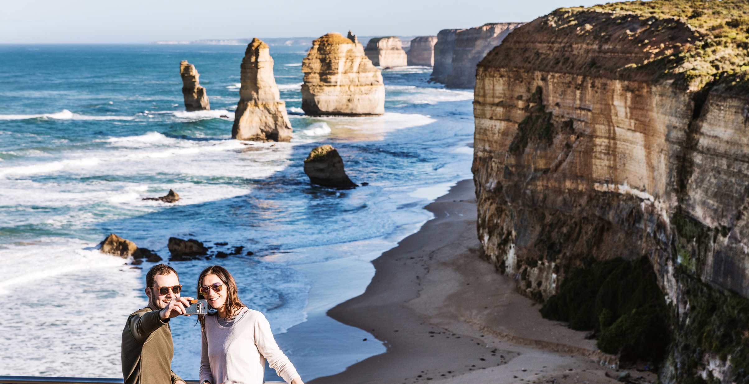 Couple taking selfie in front of 12 Apostles at the lookout point.